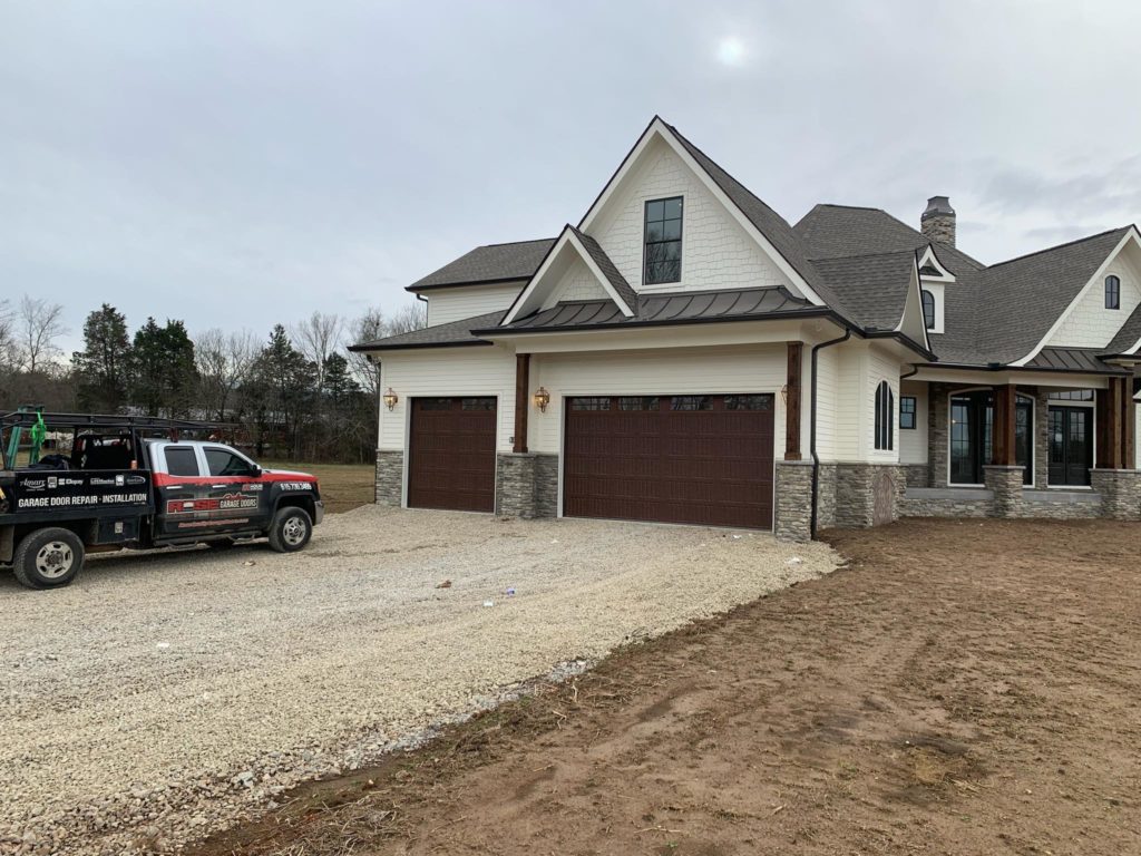 Big house with front garage doors in dark chocolate