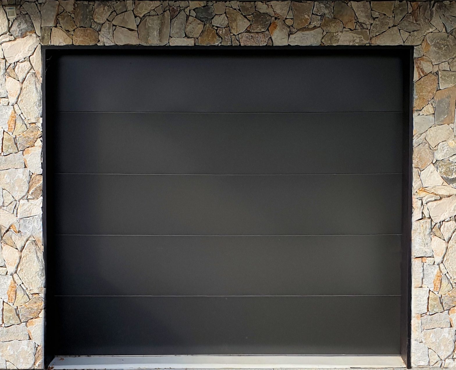 grey-garage-door-with-stone-frame